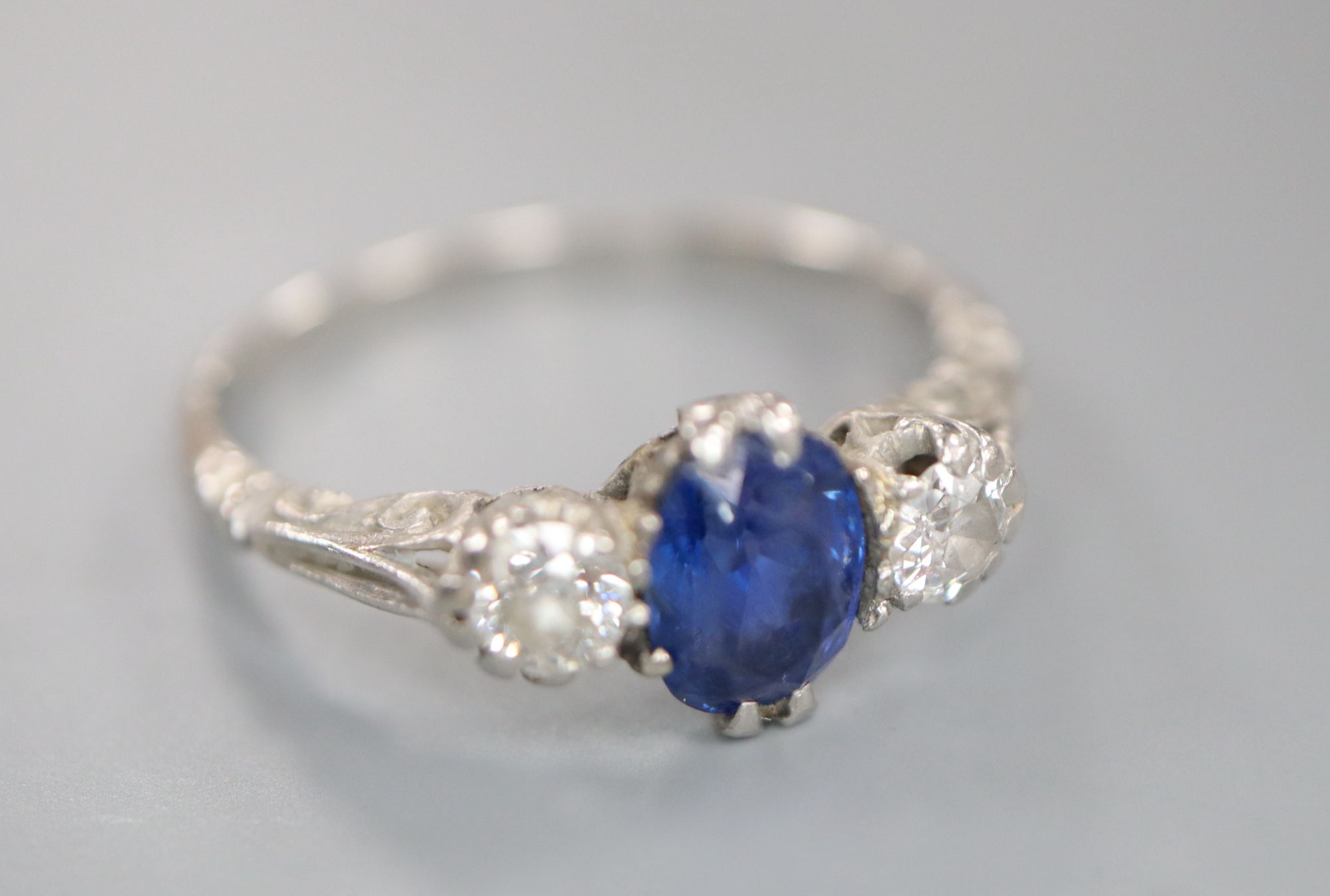 A mid 20th century white metal, sapphire and diamond three stone ring, size P, gross 3.6 grams.